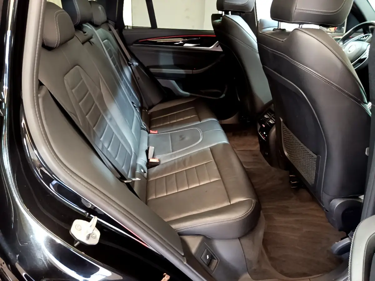 Vue intérieure côté gauche des sièges arrière en cuir noir du BMW X3 xDrive20d 2019 avec finitions Luxury.