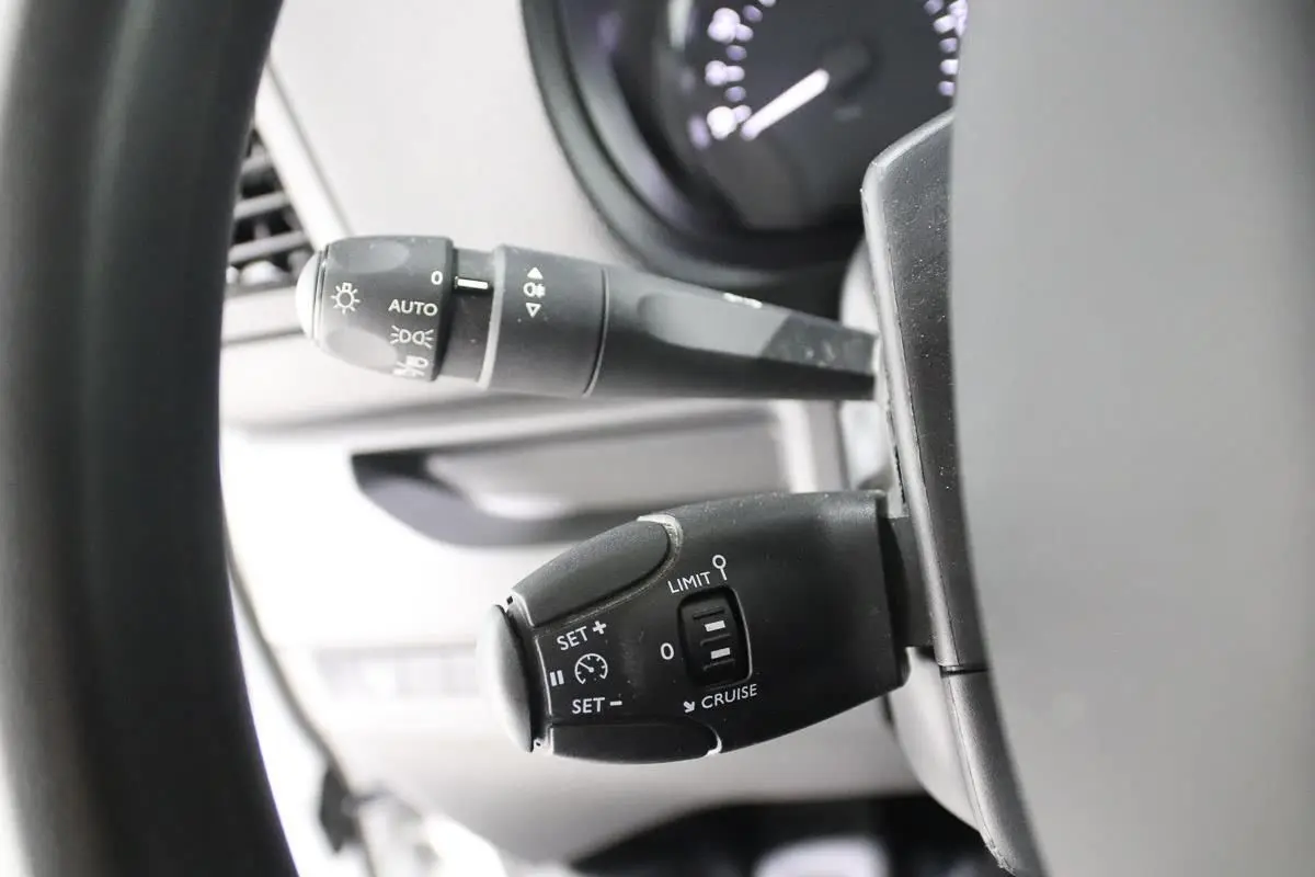 Gros plan sur les commandes de régulateur de vitesse et des feux au volant d'un Citroën Jumpy blanc de 2019.