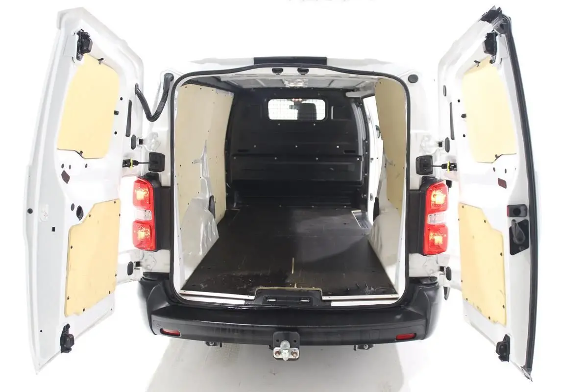 Vue arrière du Citroën Jumpy blanc avec portes ouvertes montrant l'intérieur utilitaire équipé d'un kit bois et attelage.