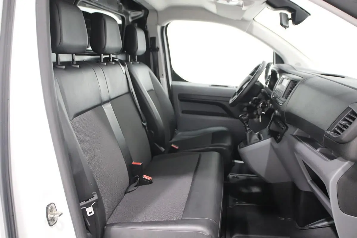 Intérieur du Citroën Jumpy Fourgon XL 2019, vue côté conducteur montrant sièges noirs et tableau de bord fonctionnel.