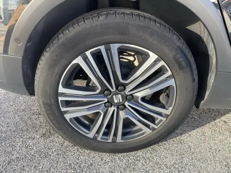 Gros plan sur la roue avant gauche du SEAT Arona noir 2023, mettant en valeur la jante alliage au design moderne.