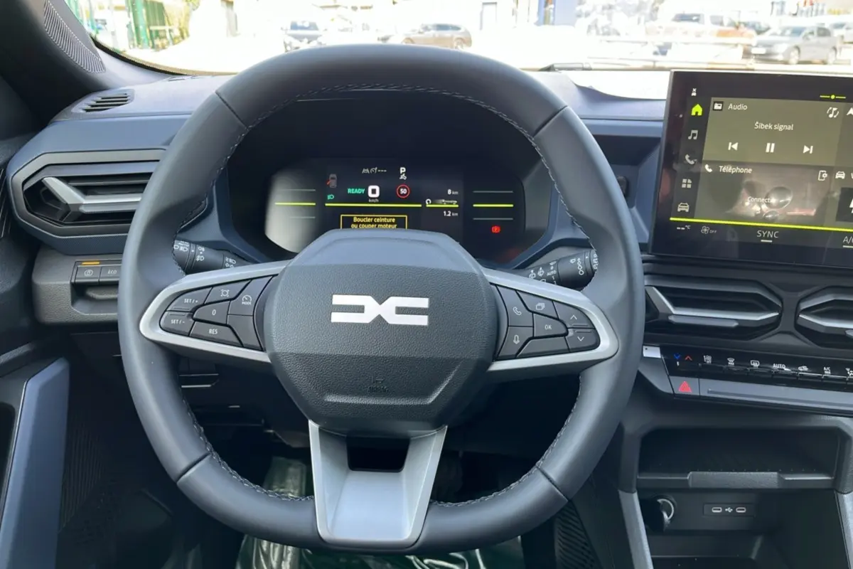 Vue centrée sur le volant cuir du Dacia Bigster Hybrid 155 Expression Plus avec tableau de bord numérique et écran tactile.