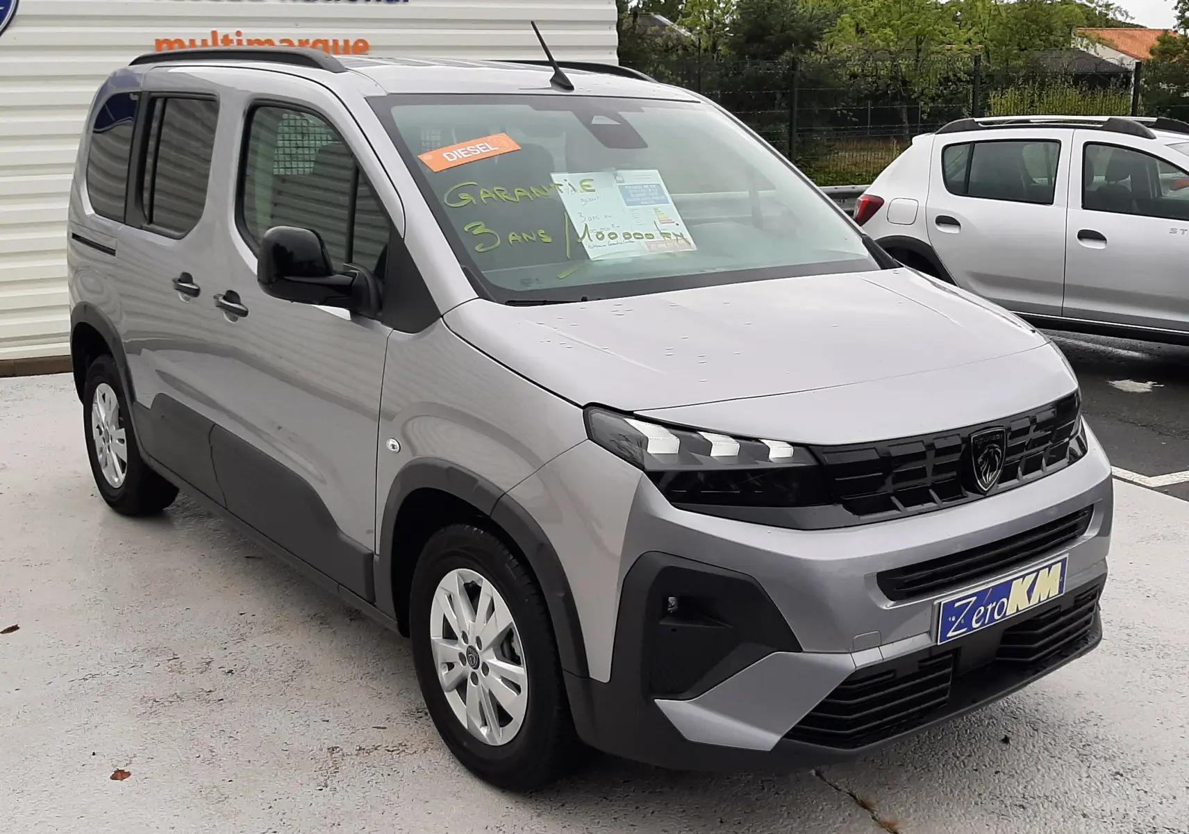 PEUGEOT RIFTER gris acier vu en 3/4 avant droit, avec vitres arrière surteintées et jantes alu 16 pouces.