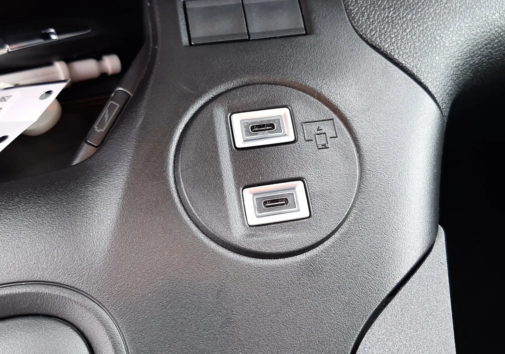 Gros plan sur deux ports USB-C intégrés dans la console centrale noire du Peugeot Rifter gris acier.