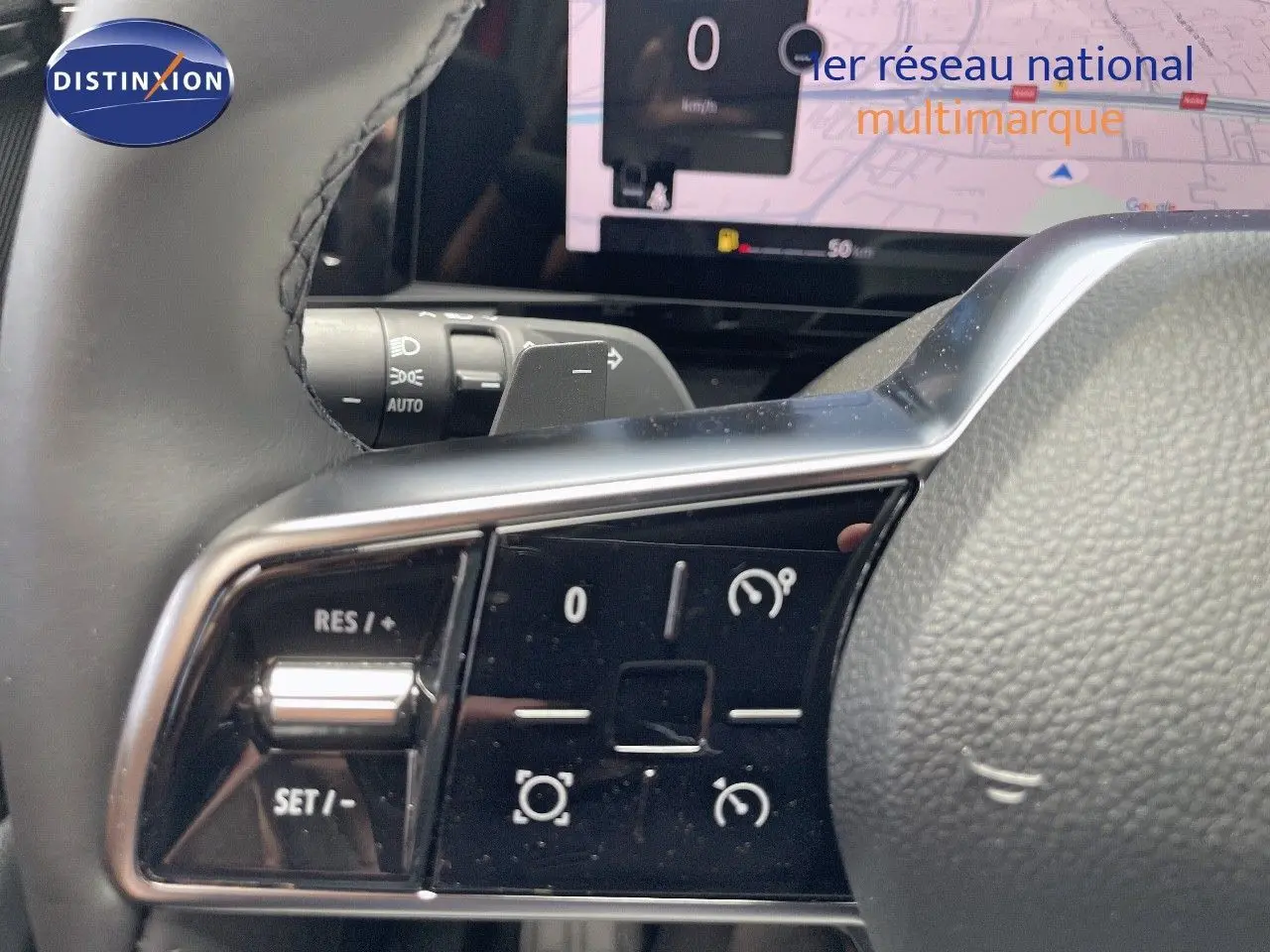 Gros plan sur les commandes au volant du Renault Austral E-Tech Hybrid 2025, avec écran numérique en arrière-plan.