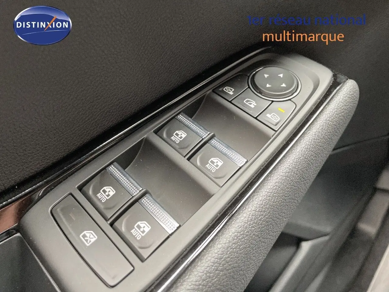 Gros plan sur les commandes de lève-vitres et rétroviseurs côté conducteur du Renault Austral E-Tech rouge passion 2025.