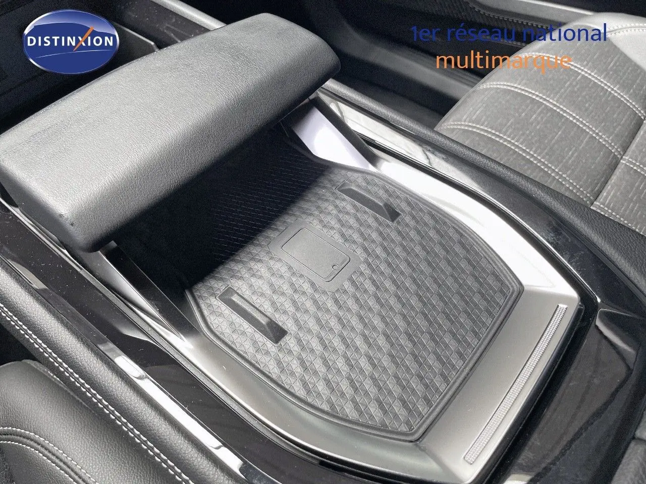 Gros plan sur la console centrale noire et le rangement avec tapis texturé du Renault Austral E-Tech 2025.