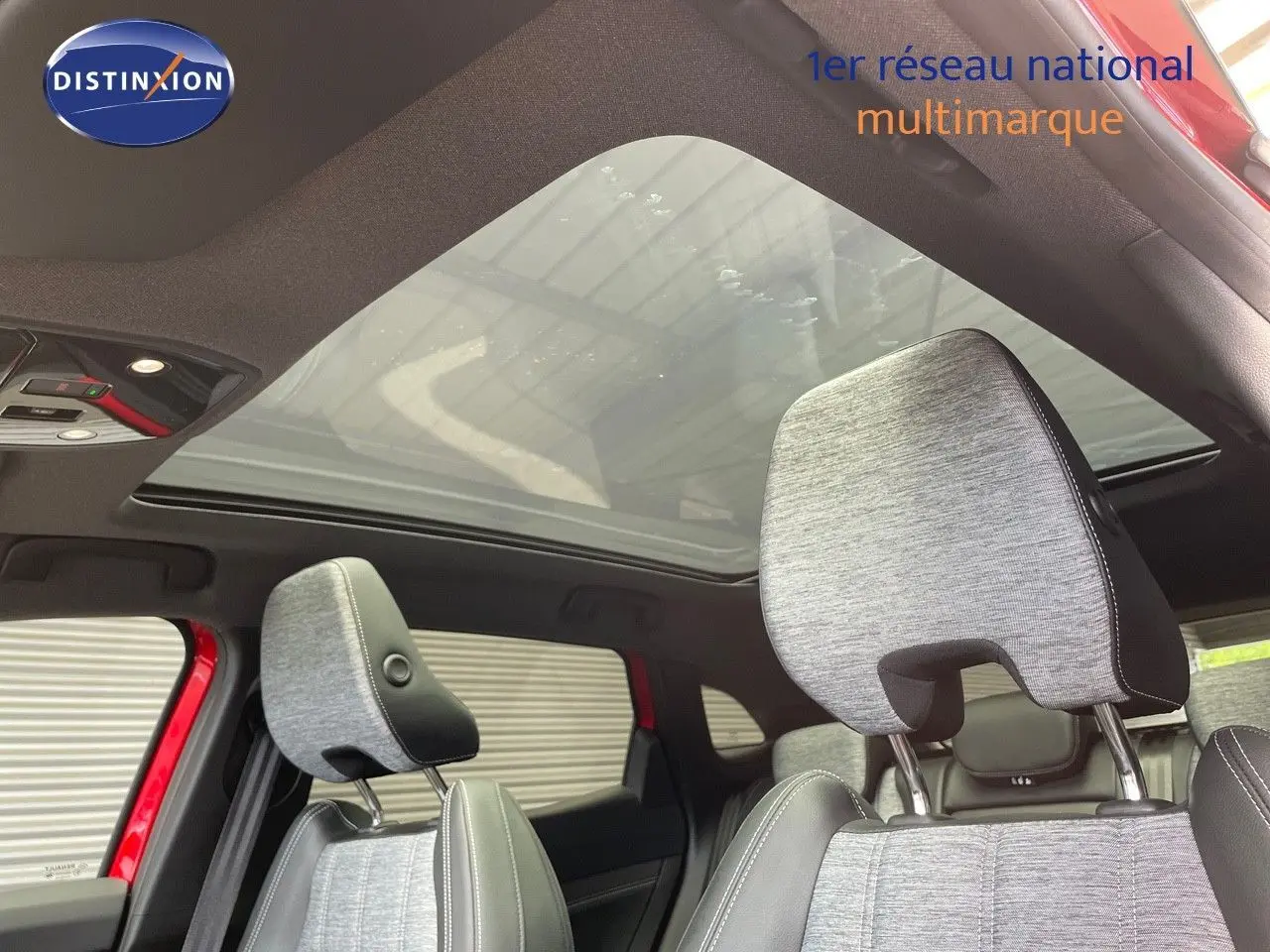 Vue intérieure du Renault Austral E-Tech hybride 2025, sièges gris clair et toit panoramique en verre.
