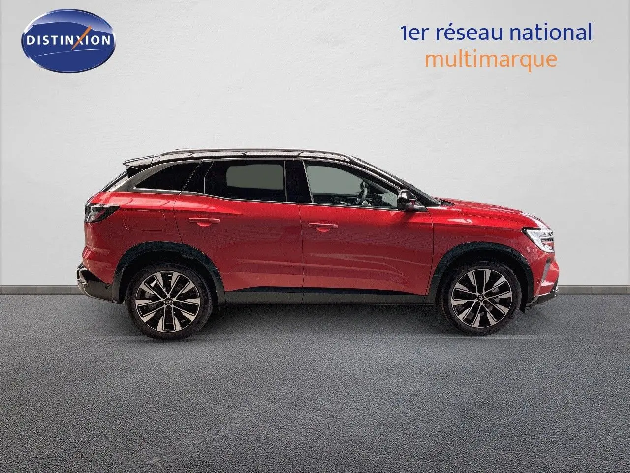 Profil droit d'un Renault Austral 2025 rouge passion métallisé avec toit noir et jantes alliage bicolores.