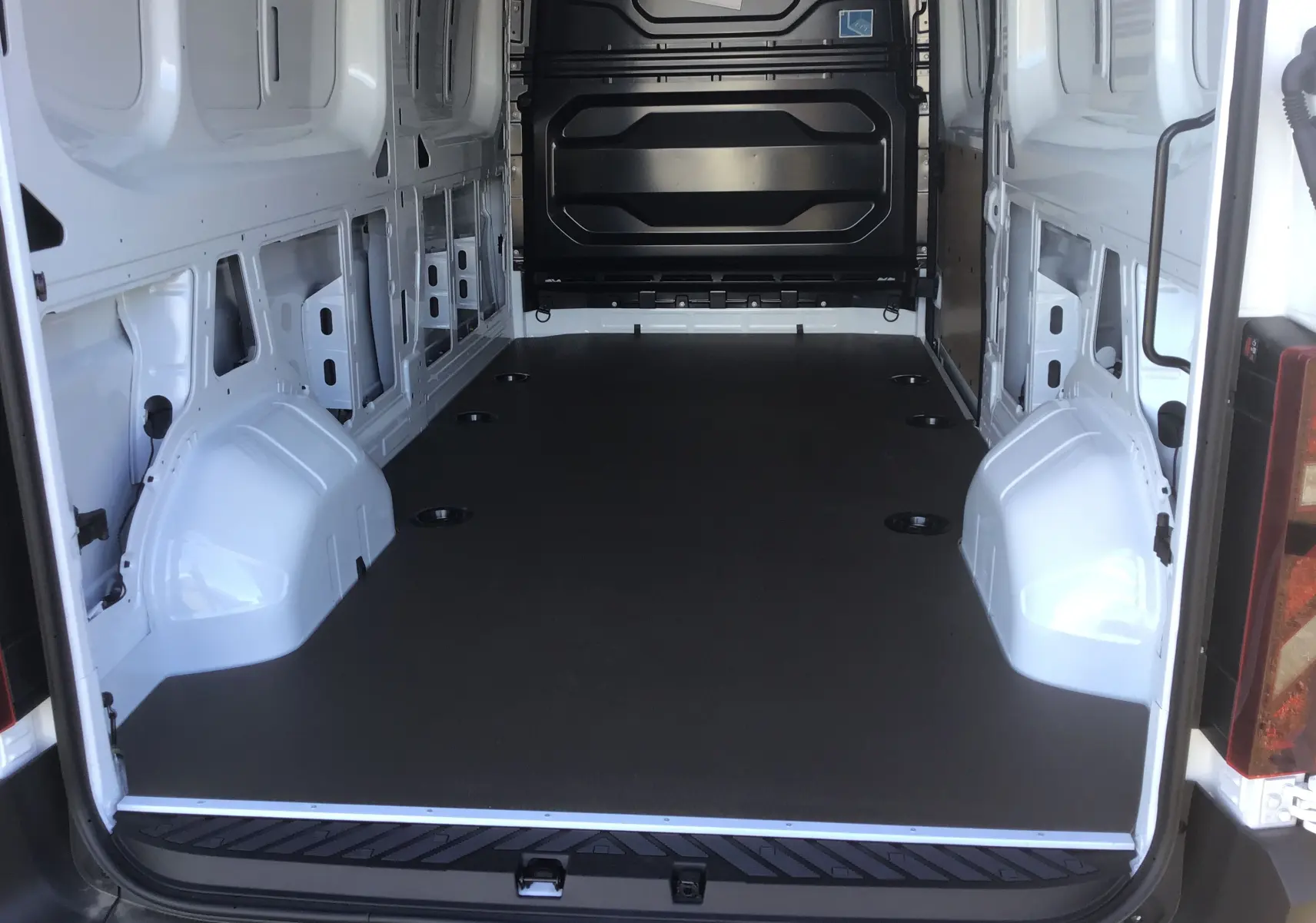 Intérieur du Renault Master blanc L3H2 vu depuis l'arrière, montrant l'espace de chargement vide et le plancher noir antidérapant.