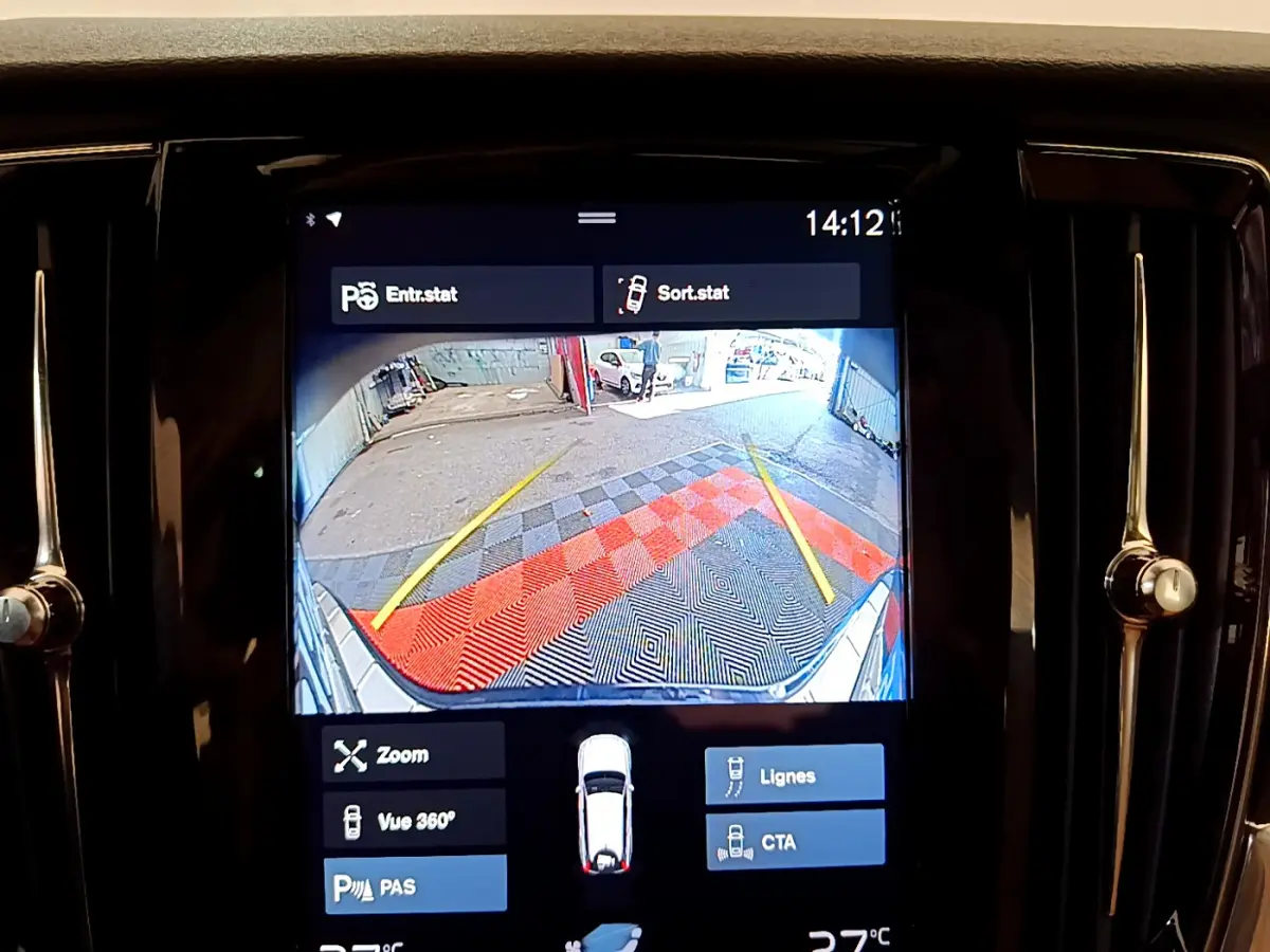 Écran tactile intérieur montrant la caméra de recul avec guidage et vue arrière du Volvo V90 Cross Country bleu.