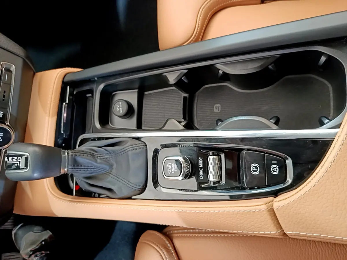 Vue plongeante sur la console centrale cuir beige du Volvo V90 Cross Country 2019 avec levier de vitesse et commandes.