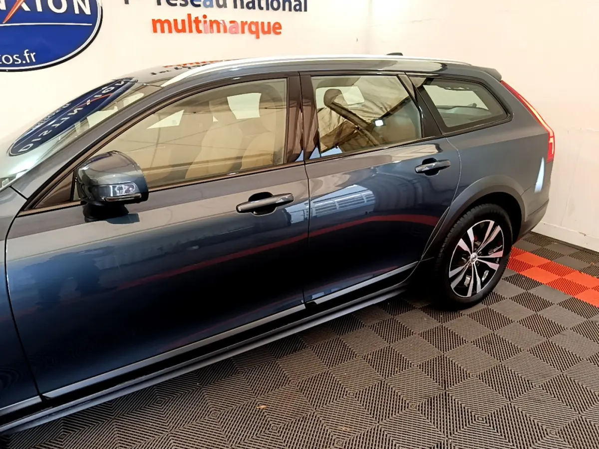 Vue latérale droite d'un Volvo V90 Cross Country bleu avec jantes alliage et rétroviseurs noirs.