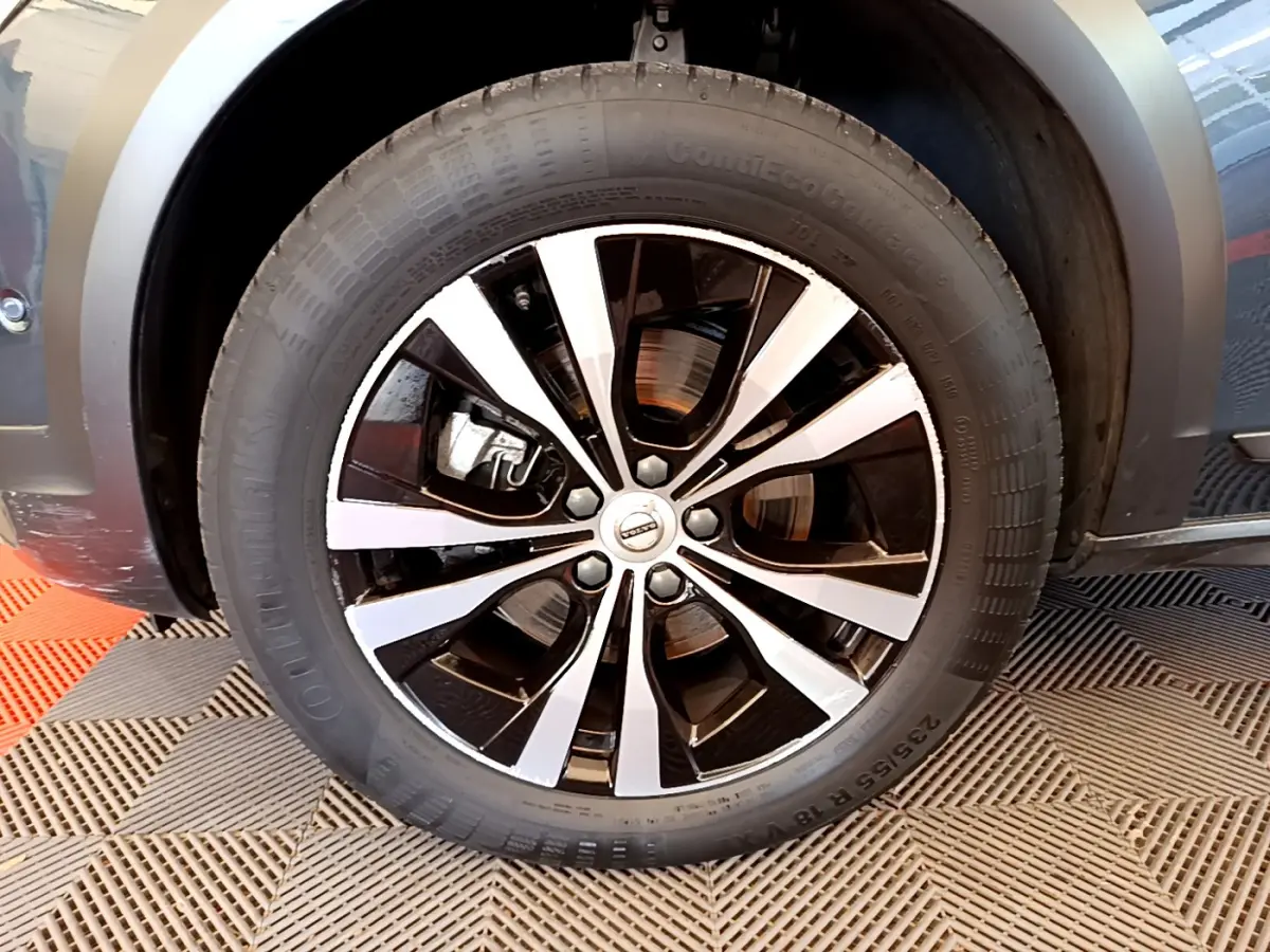 Gros plan sur la roue avant droite avec jante alliage bicolore du Volvo V90 Cross Country bleu 2019.