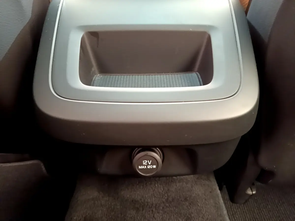 Prise 12V noire vue de face sous un rangement central intérieur du Volvo V90 Cross Country bleu 2019.