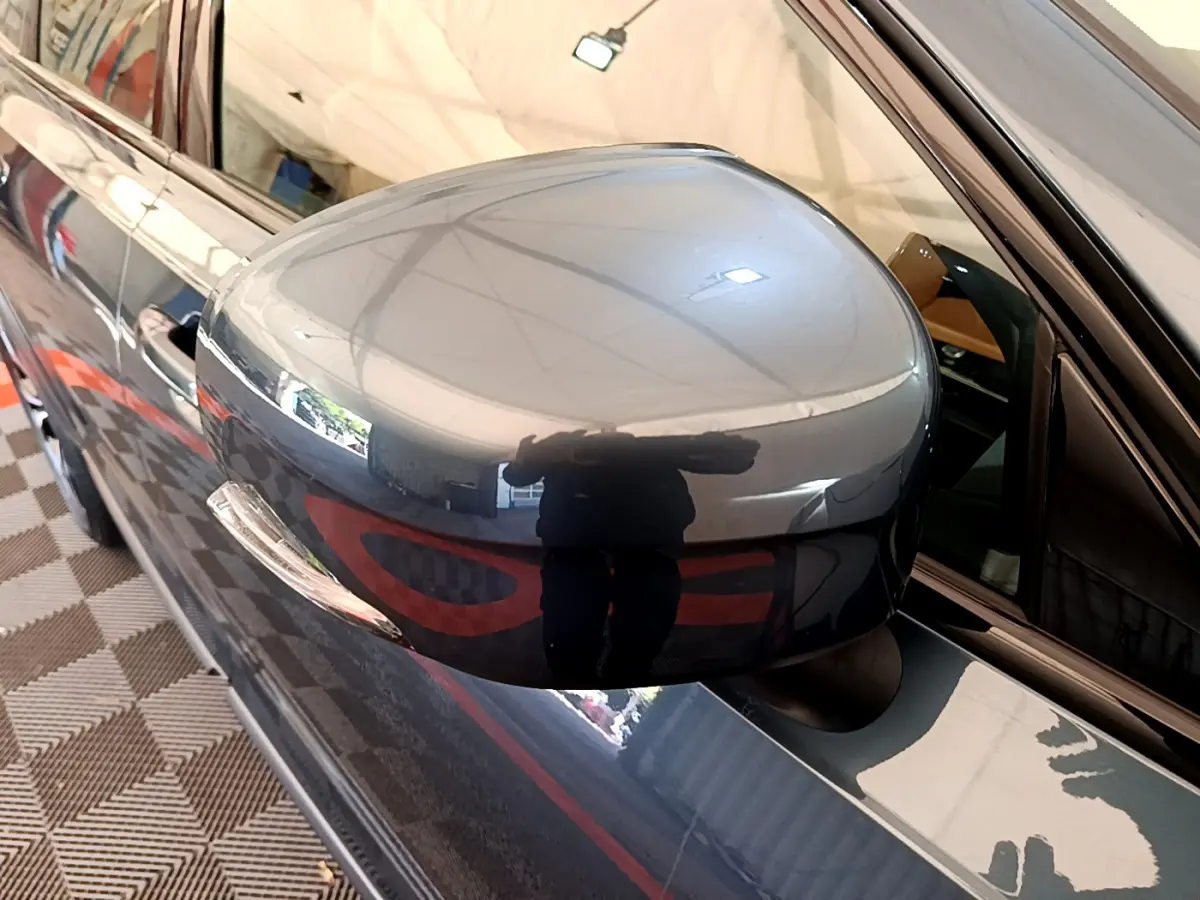 Rétroviseur côté gauche bleu brillant du Volvo V90 Cross Country 2019, avec reflet et partie de la portière visible.