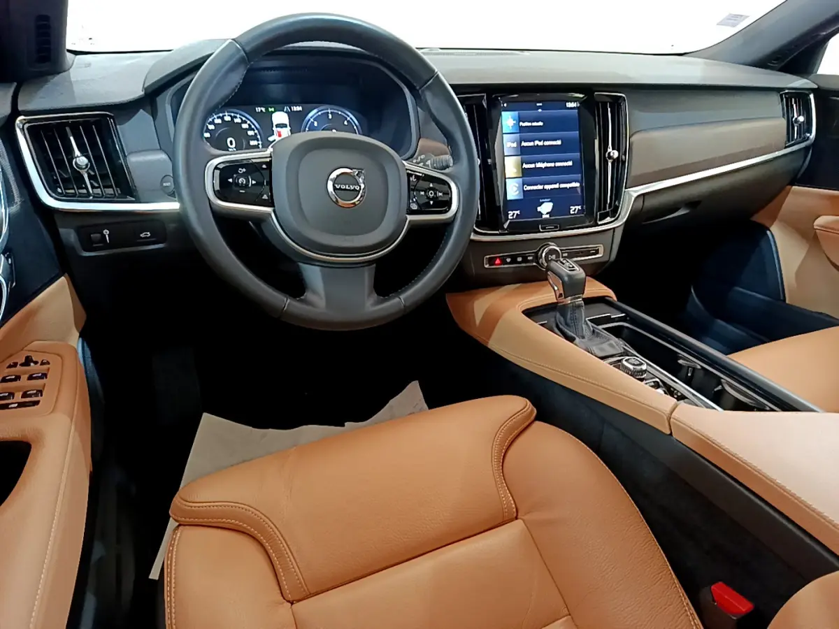 Intérieur de Volvo V90 Cross Country 2019 vu de face, avec sièges cuir marron et tableau de bord noir moderne.