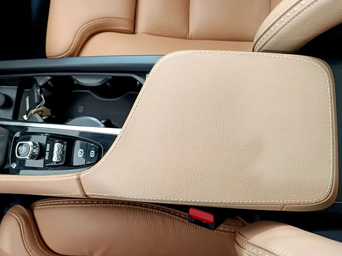 Vue rapprochée de la console centrale beige et des sièges en cuir marron clair d'un Volvo V90 Cross Country.