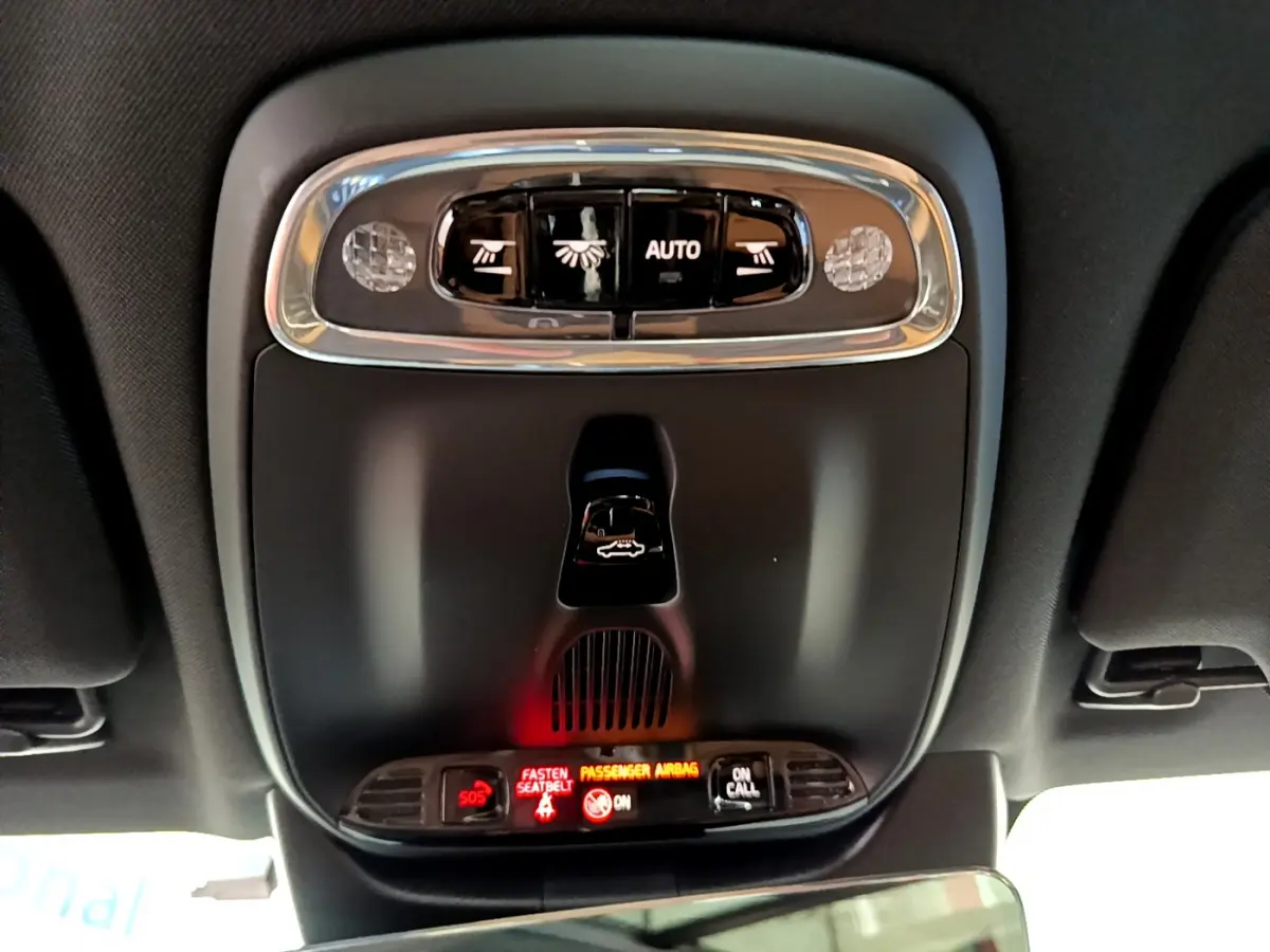 Vue intérieure du plafonnier noir avec commandes d'éclairage et indicateurs lumineux du Volvo V90 Cross Country bleu.