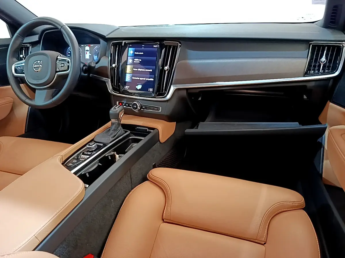 Vue intérieure avant droite du Volvo V90 Cross Country 2019, montrant tableau de bord noir et sièges cuir beige.