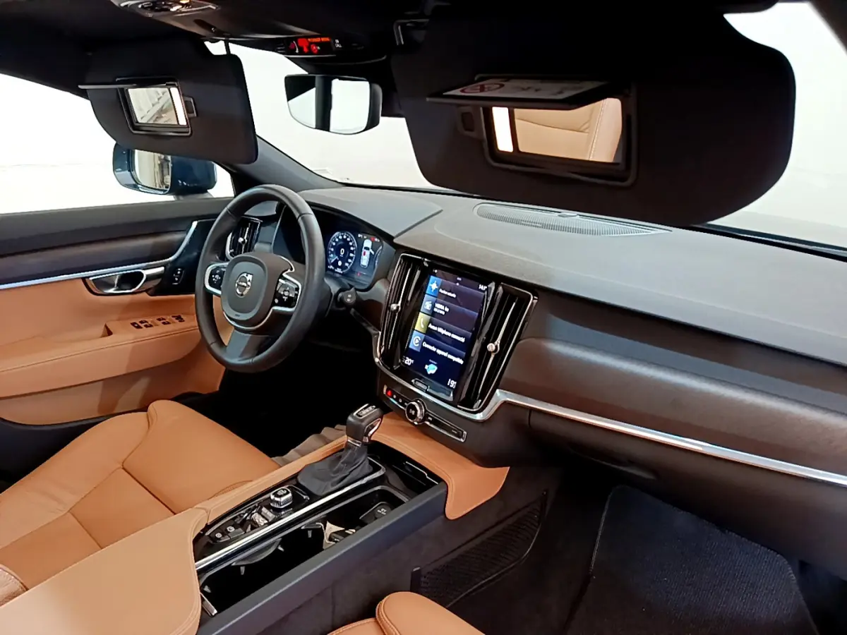 Vue intérieure côté conducteur du tableau de bord et console centrale cuir marron du Volvo V90 Cross Country 2019.
