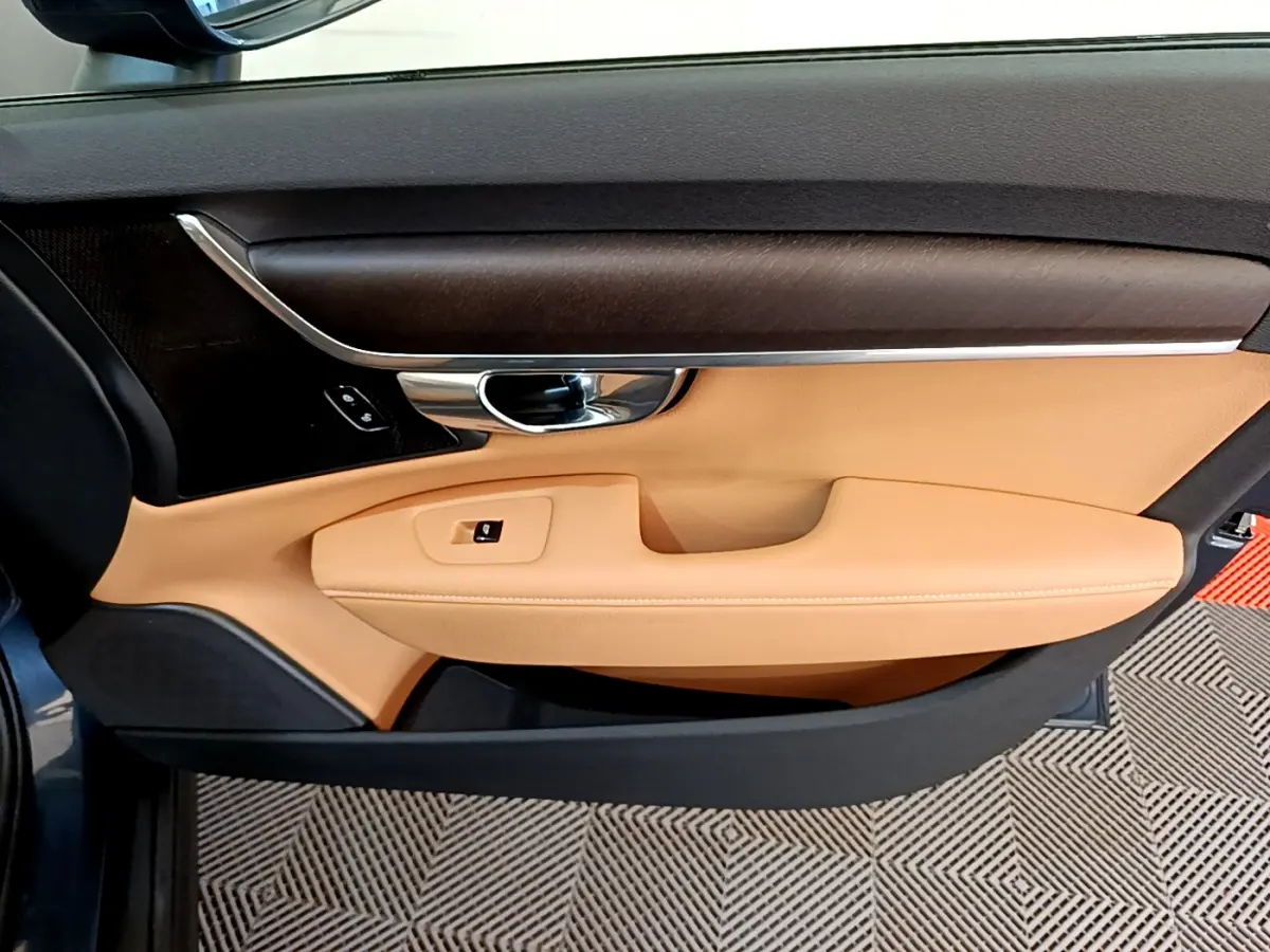 Vue intérieure côté gauche de la porte avant beige et bois foncé du Volvo V90 Cross Country bleu 2019.