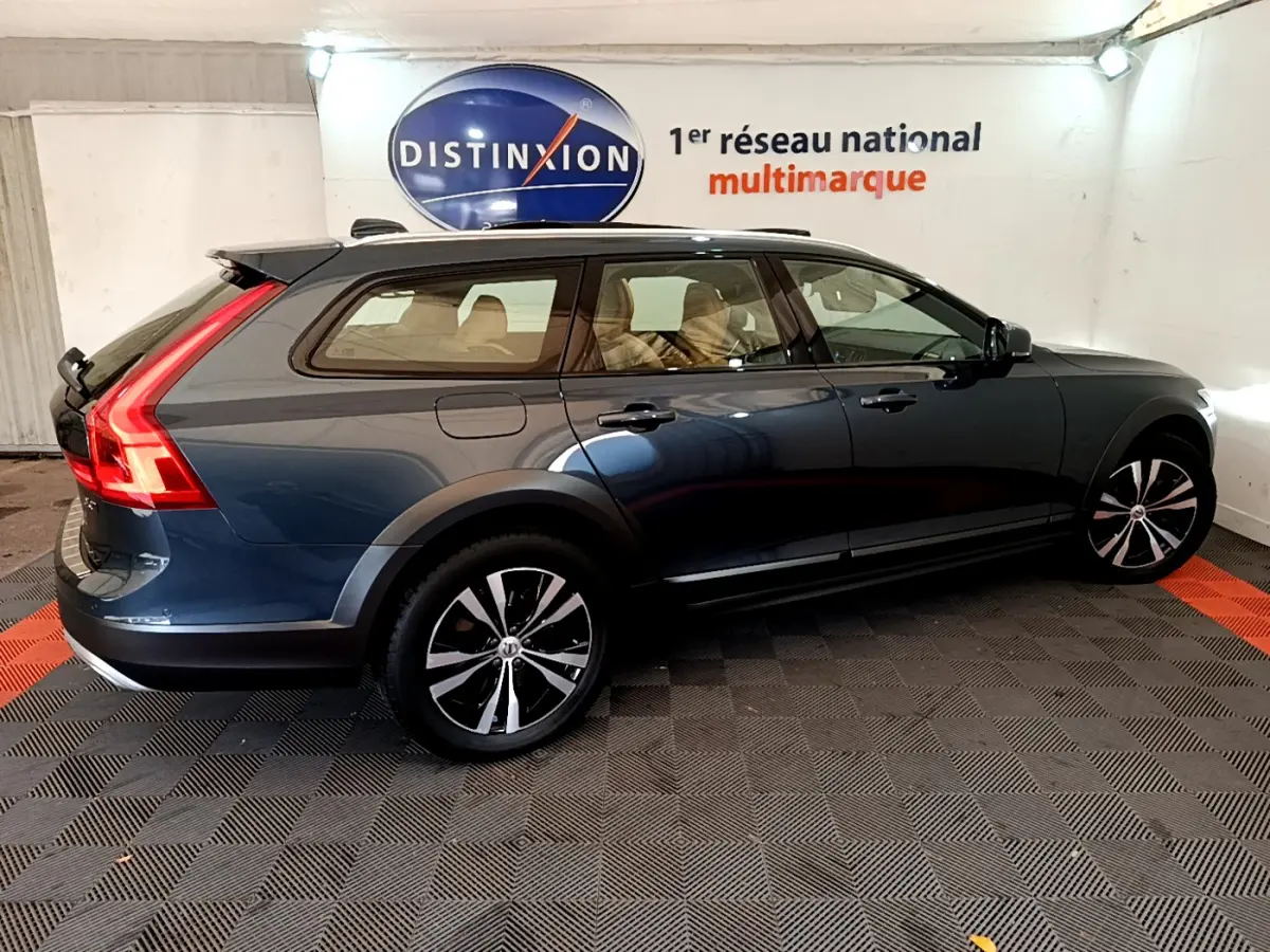 Vue latérale droite d’un Volvo V90 Cross Country bleu avec jantes alliage et feux arrière LED distinctifs.