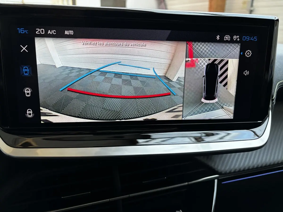 Écran tactile de la Peugeot 208 Hybrid gris foncé montrant la caméra de recul et l'aide au stationnement arrière.