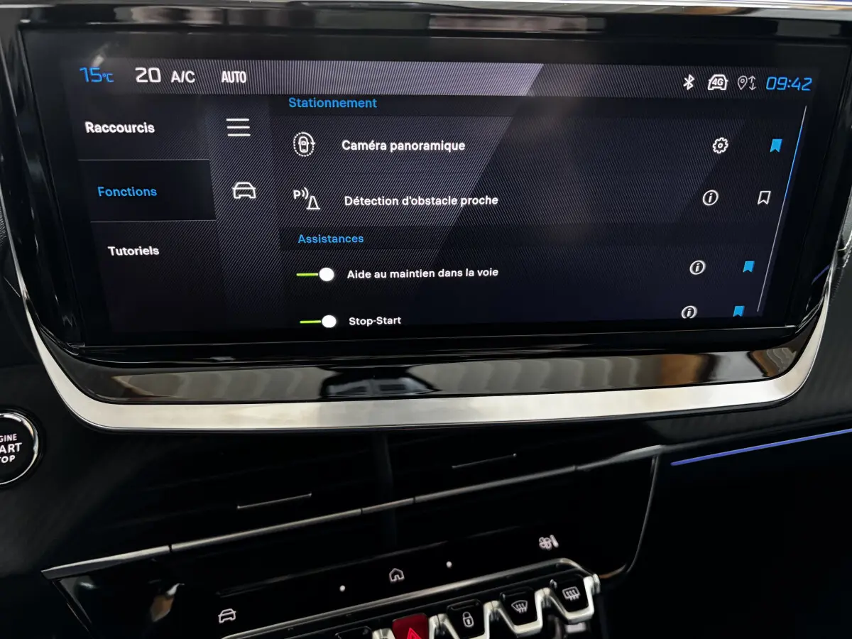 Écran tactile central de la Peugeot 208 Hybrid 136 GT montrant les options d'assistance à la conduite, intérieur noir.