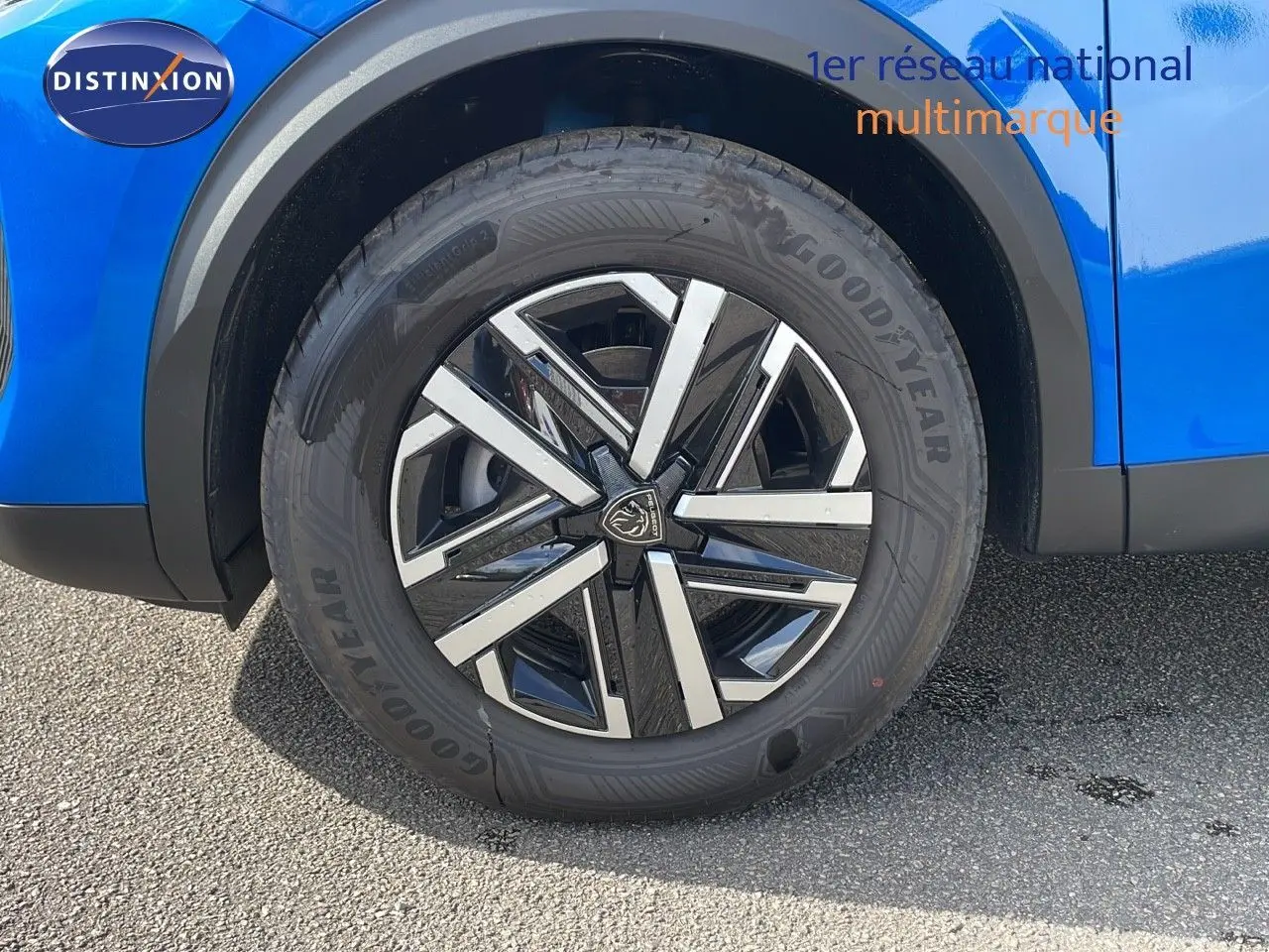 Gros plan sur la roue avant gauche d’un Peugeot 2008 bleu Vertigo Metal avec jante alliage noire et argentée.