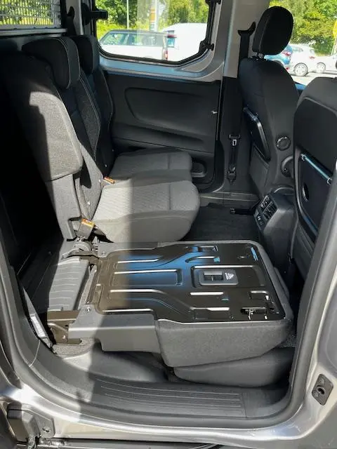 Vue intérieure côté droit du Peugeot Rifter gris foncé 2024, siège arrière rabattable mettant en valeur l'espace modulable.