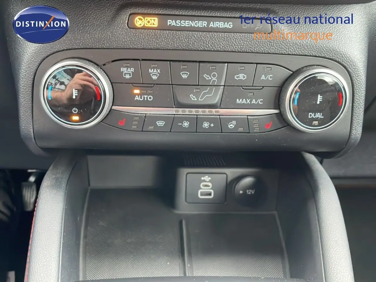 Détail de la console centrale du Ford Kuga 2024, montrant les commandes de climatisation et ports USB en intérieur noir.
