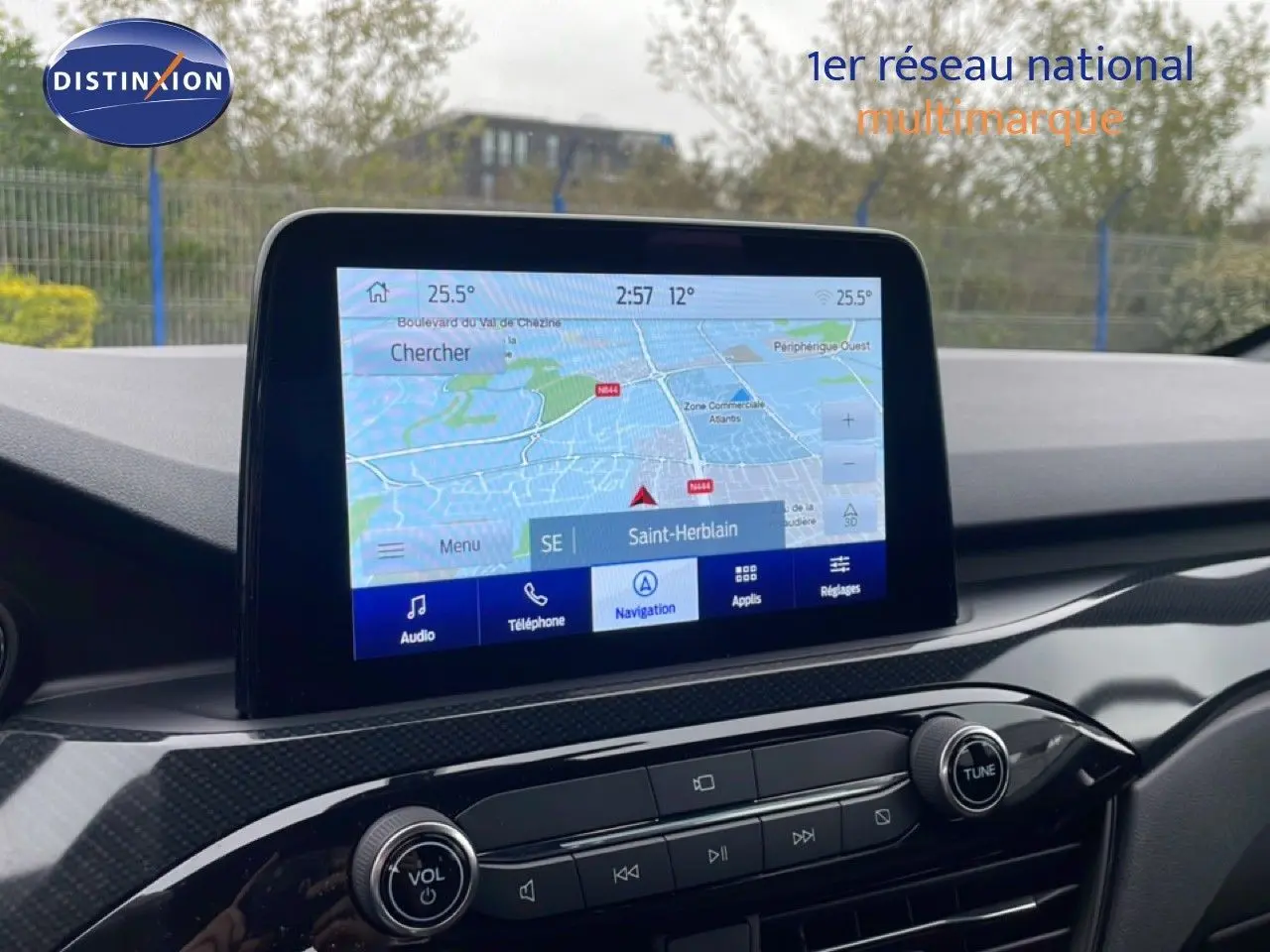 Écran tactile de navigation du Ford Kuga 2024, affichant une carte avec options audio et téléphone, intérieur noir.