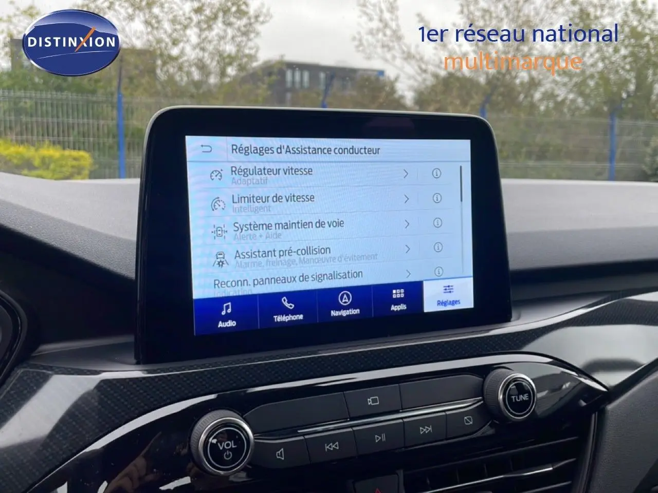 Vue intérieure du tableau de bord du Ford Kuga 2024 avec écran tactile affichant les réglages d’assistance conducteur.