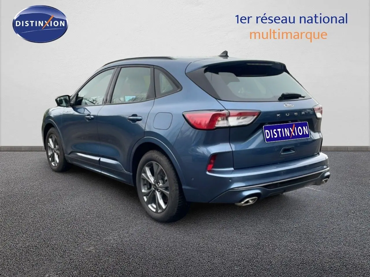 Ford Kuga 2024 bleu Vapor Metal vu en 3/4 arrière droit, avec feux LED et double sortie d’échappement chromée.