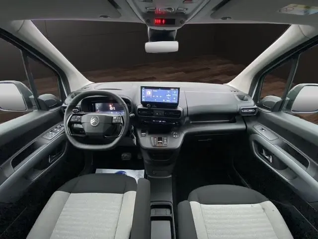 Vue intérieure avant du Citroën Berlingo 2025 avec tableau de bord moderne, écran tactile central et sièges bicolores.