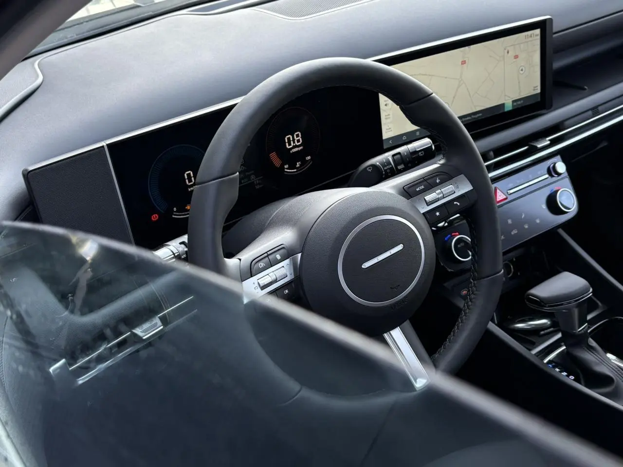 Vue rapprochée de l'intérieur du Hyundai Tucson 2025, volant cuir noir et tableau de bord numérique avec écran tactile large.