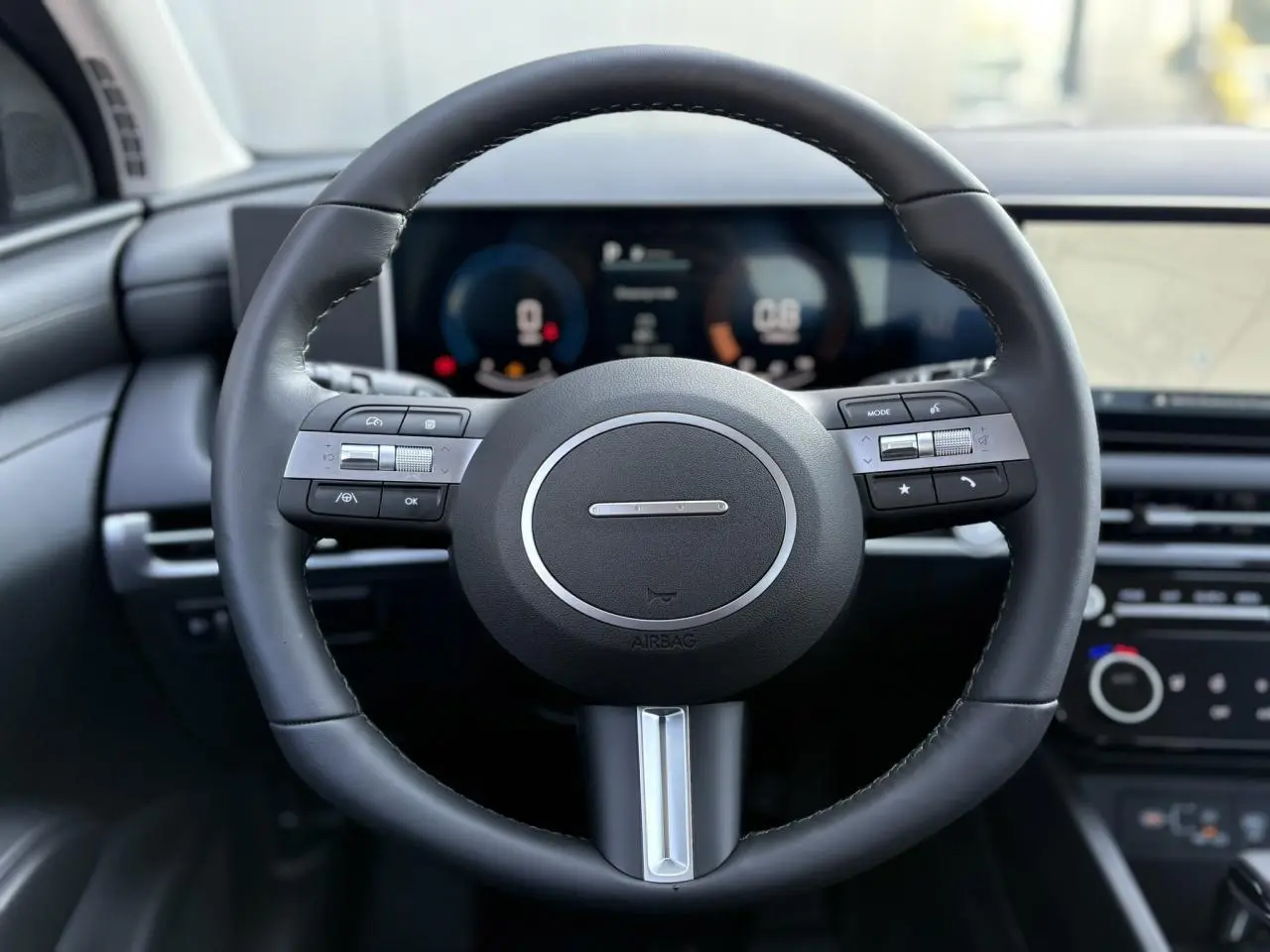 Volant cuir noir avec commandes intégrées, tableau de bord numérique et écran tactile du Hyundai Tucson 2025.