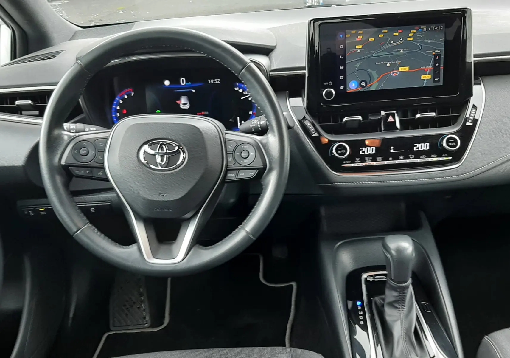 Vue intérieure du tableau de bord de la Toyota Corolla 122 CH Dynamic 2022, avec volant, écran tactile et levier de boîte auto.