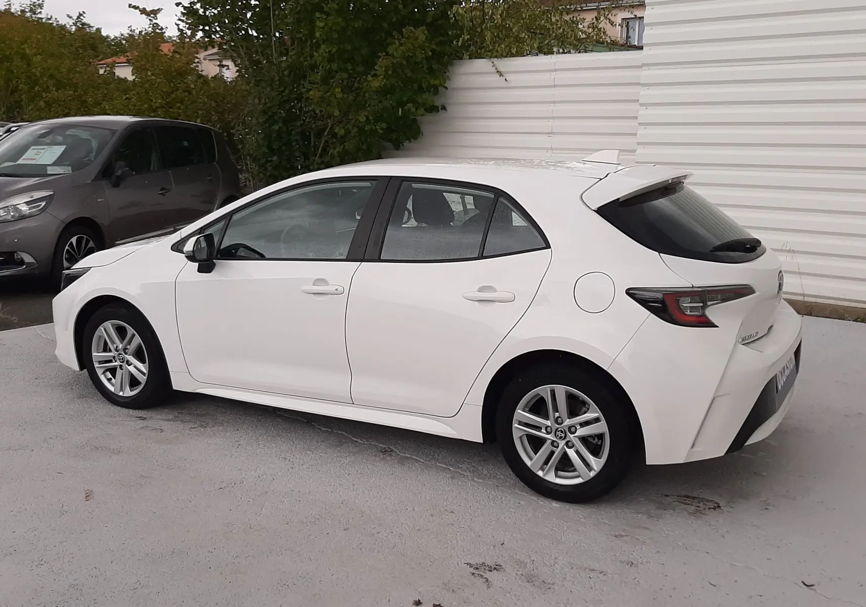 Toyota Corolla 122 CH Dynamic blanche vue de profil côté gauche, avec jantes alliage et vitres teintées arrière.