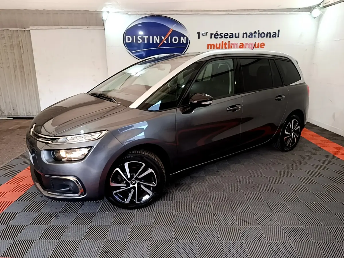 Citroën Grand C4 Spacetourer gris foncé vu de 3/4 avant droit dans un showroom intérieur.