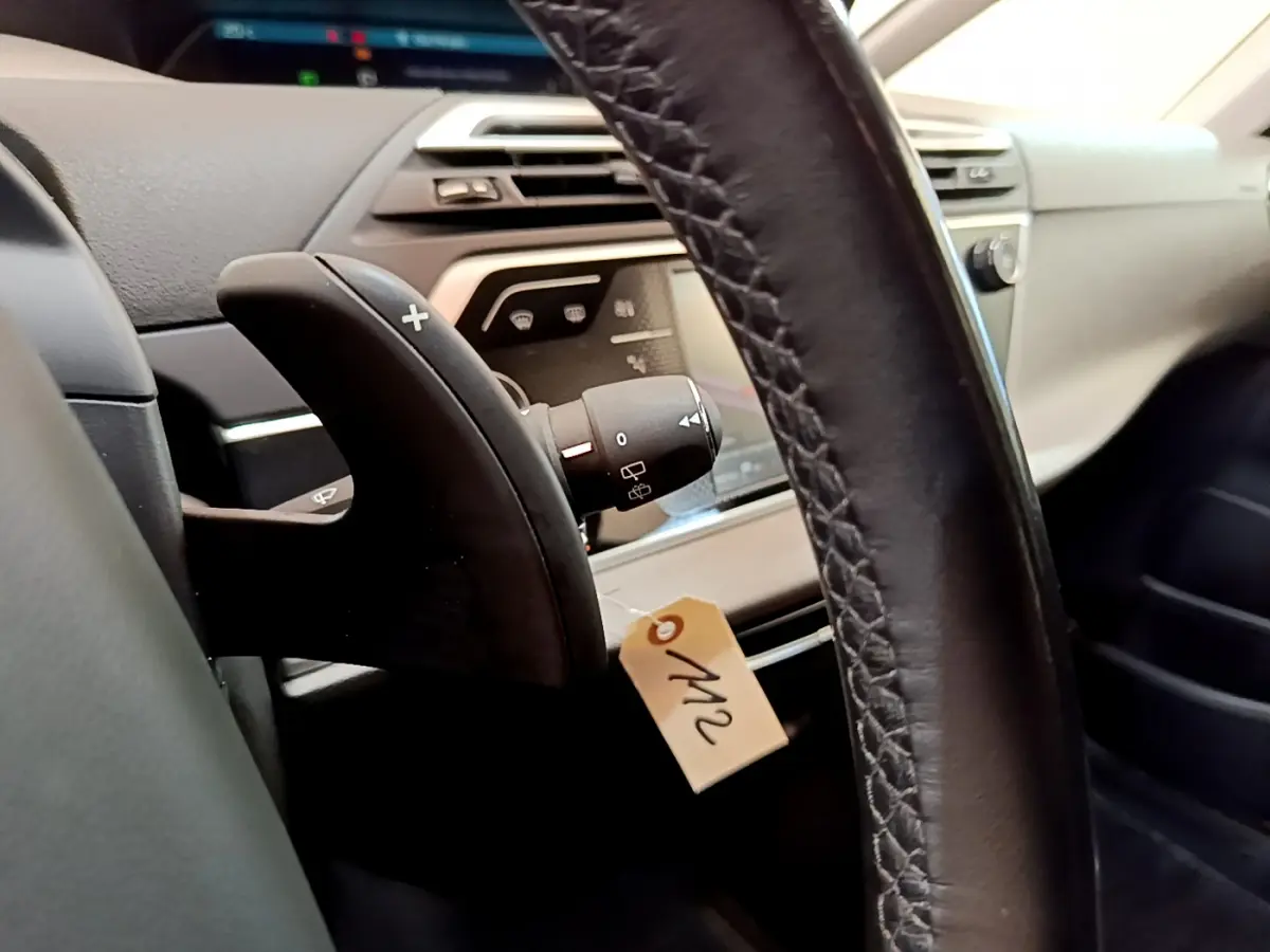 Gros plan intérieur sur le volant cuir et palettes de changement de vitesse du Citroën Grand C4 SpaceTourer gris foncé 2022.