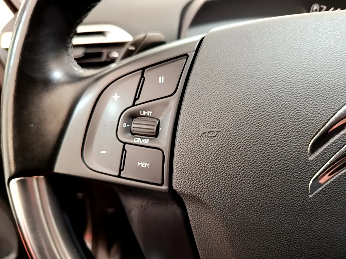 Gros plan sur le volant cuir noir du Citroën Grand C4 Spacetourer avec commandes de régulateur de vitesse.