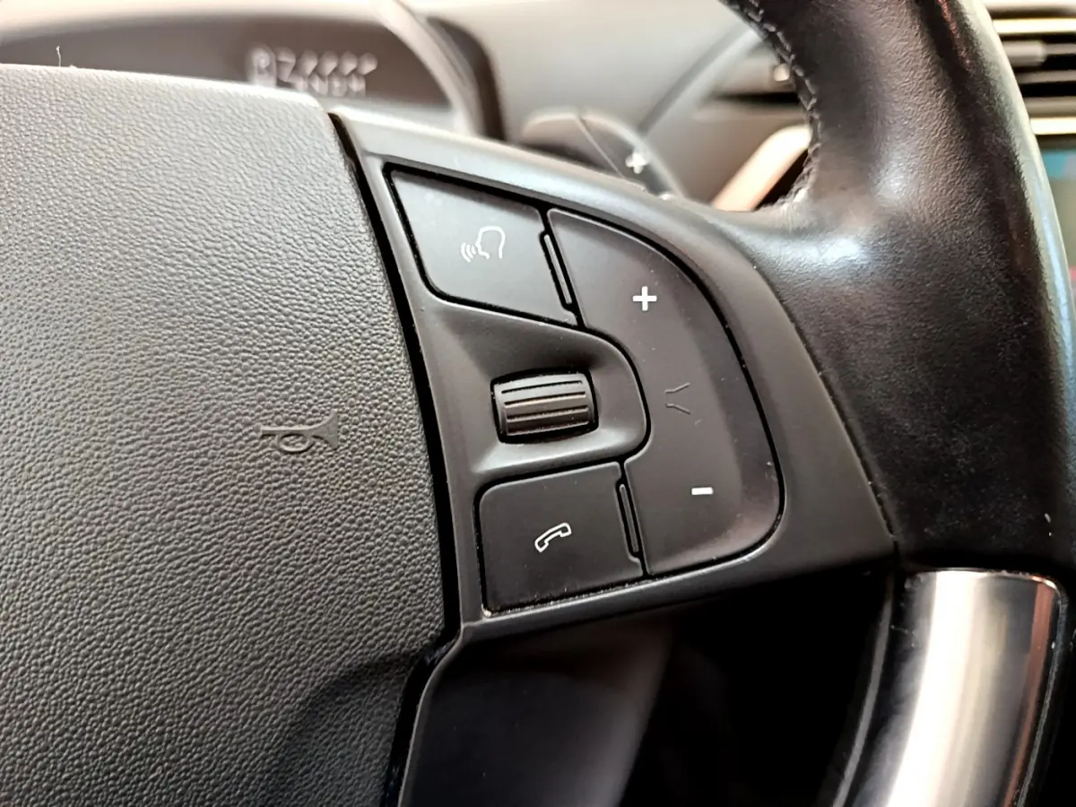 Gros plan sur les commandes du volant en cuir noir du Citroën Grand C4 Spacetourer gris foncé, version Shine 2022.