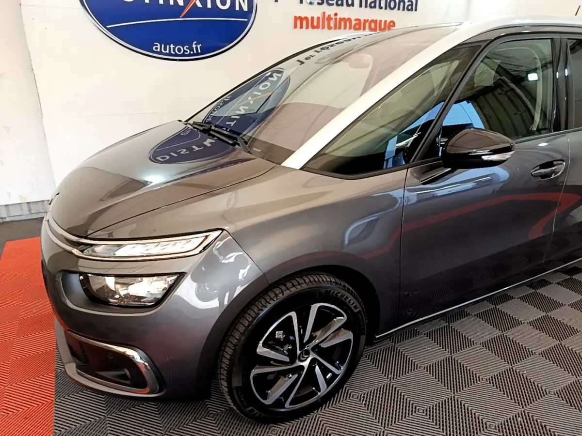 Vue 3/4 avant droit d'un Citroën Grand C4 Spacetourer gris foncé avec jantes alliage et phares LED distinctifs.