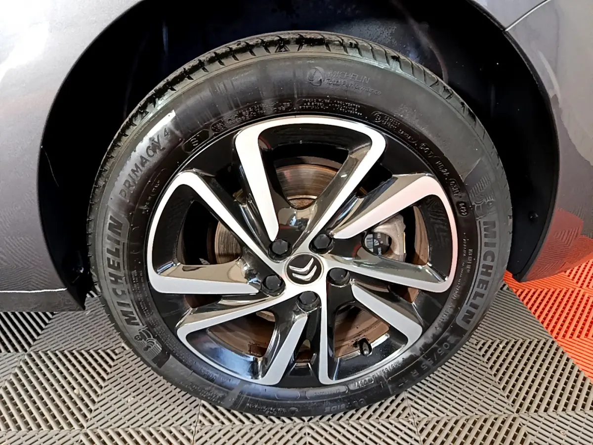 Gros plan sur la roue avant droite du Citroën Grand C4 Spacetourer gris foncé avec jante alliage bicolore et pneu Michelin.