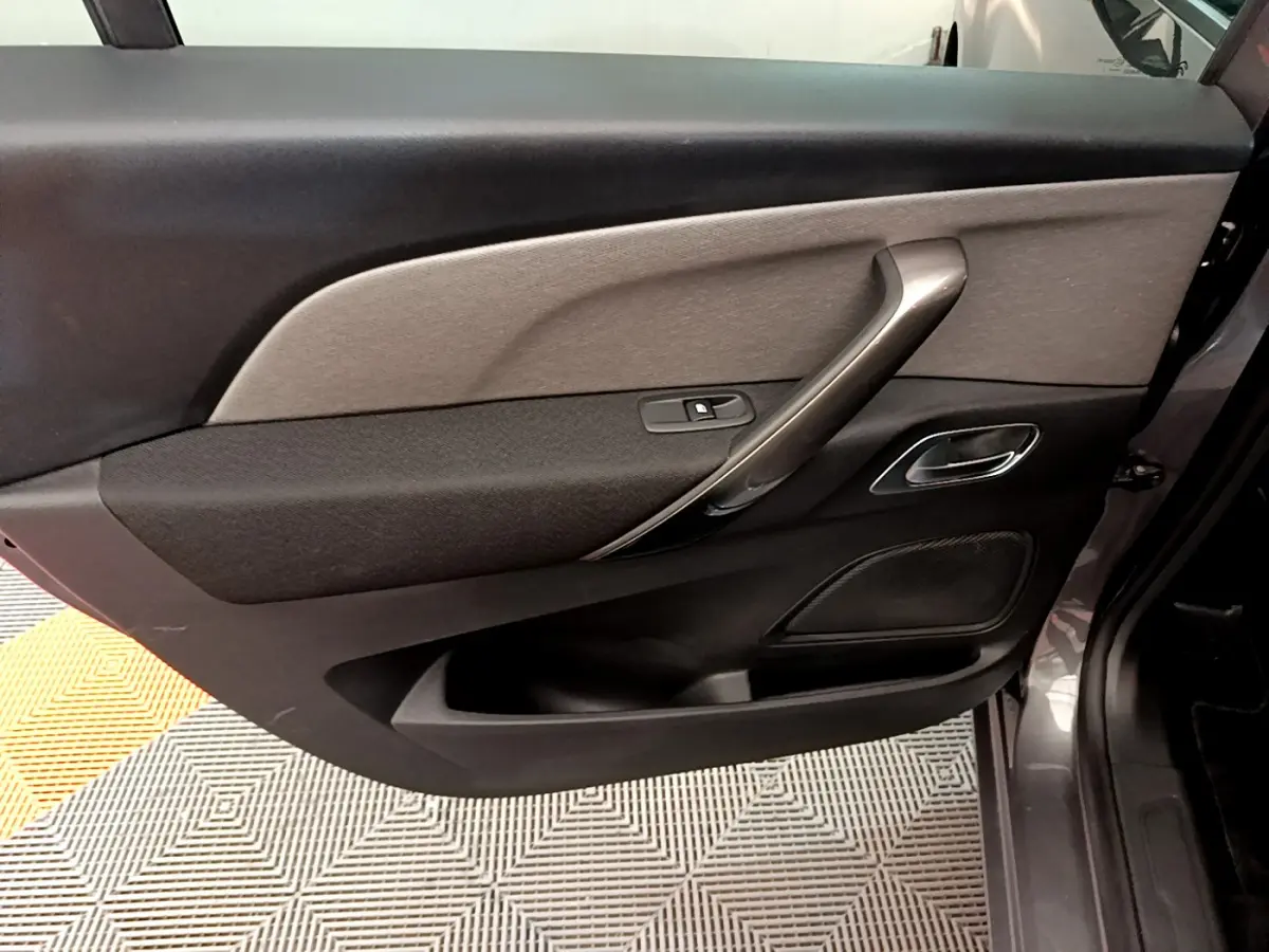 Vue intérieure de la porte côté droit gris foncé du Citroën Grand C4 Spacetourer avec poignée argentée et commande de vitre.