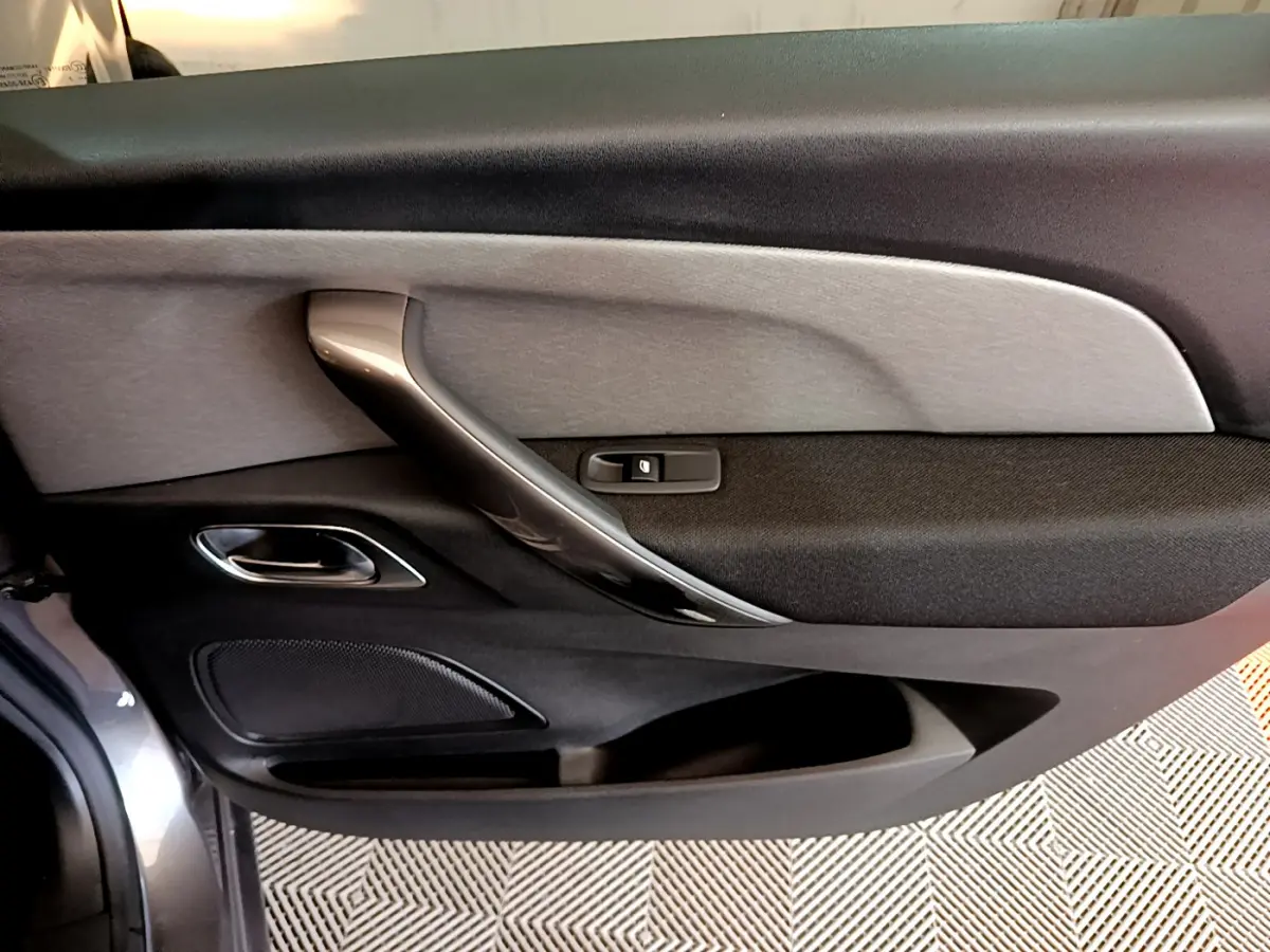 Gros plan sur la porte côté conducteur du Citroën Grand C4 Spacetourer gris foncé, avec poignée intérieure argentée.