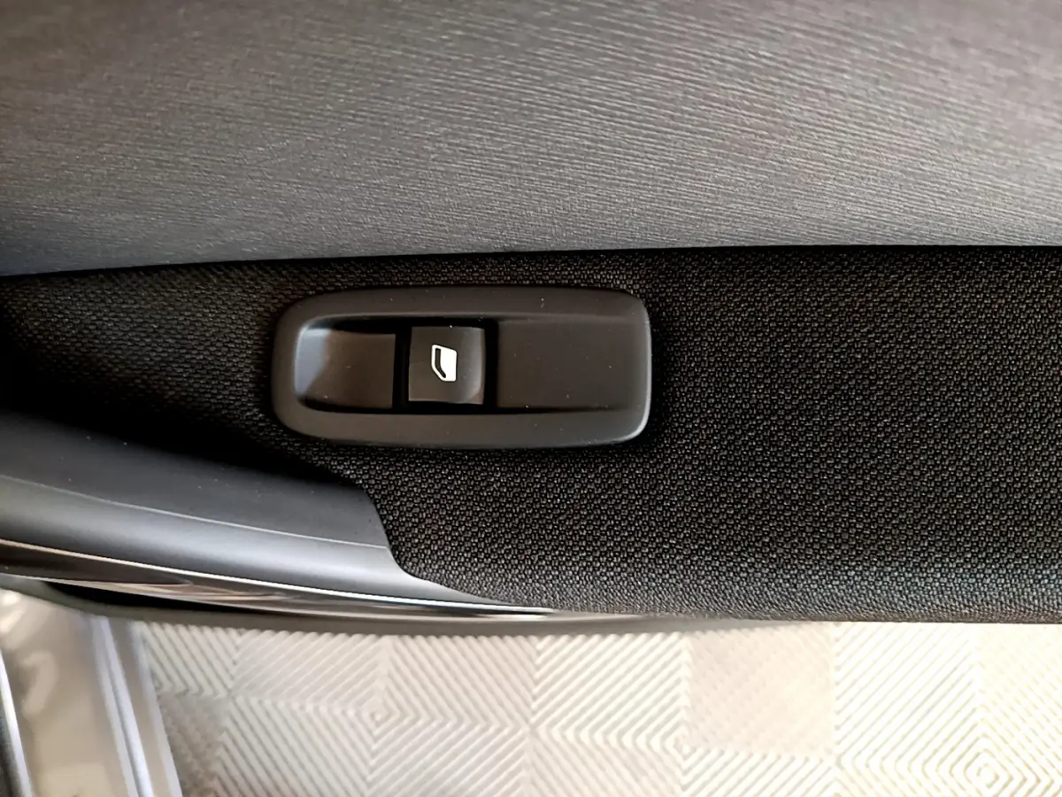 Bouton de commande de lève-vitre sur la porte intérieure d'une Citroën Grand C4 Spacetourer gris foncé.