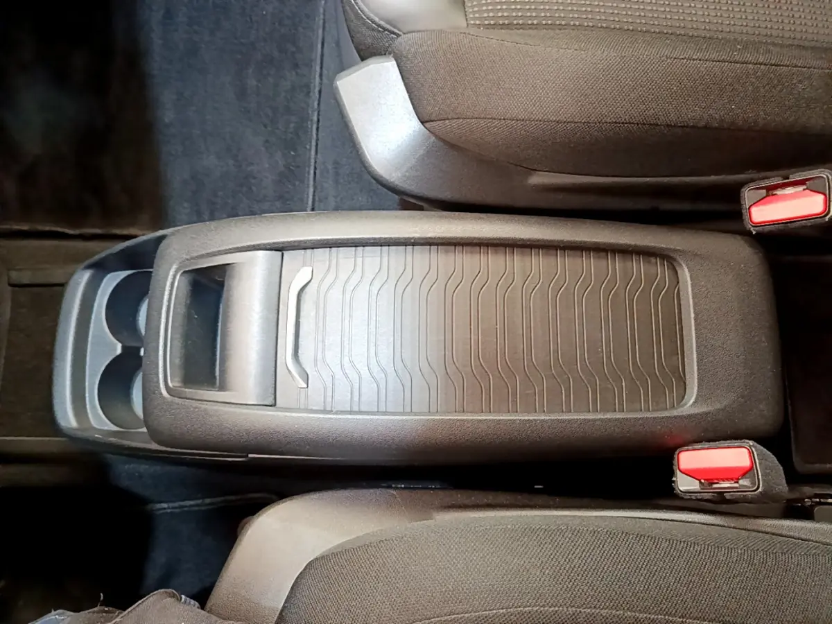 Vue plongeante sur la console centrale noire du Citroën Grand C4 Spacetourer avec porte-gobelets et sièges gris foncé.